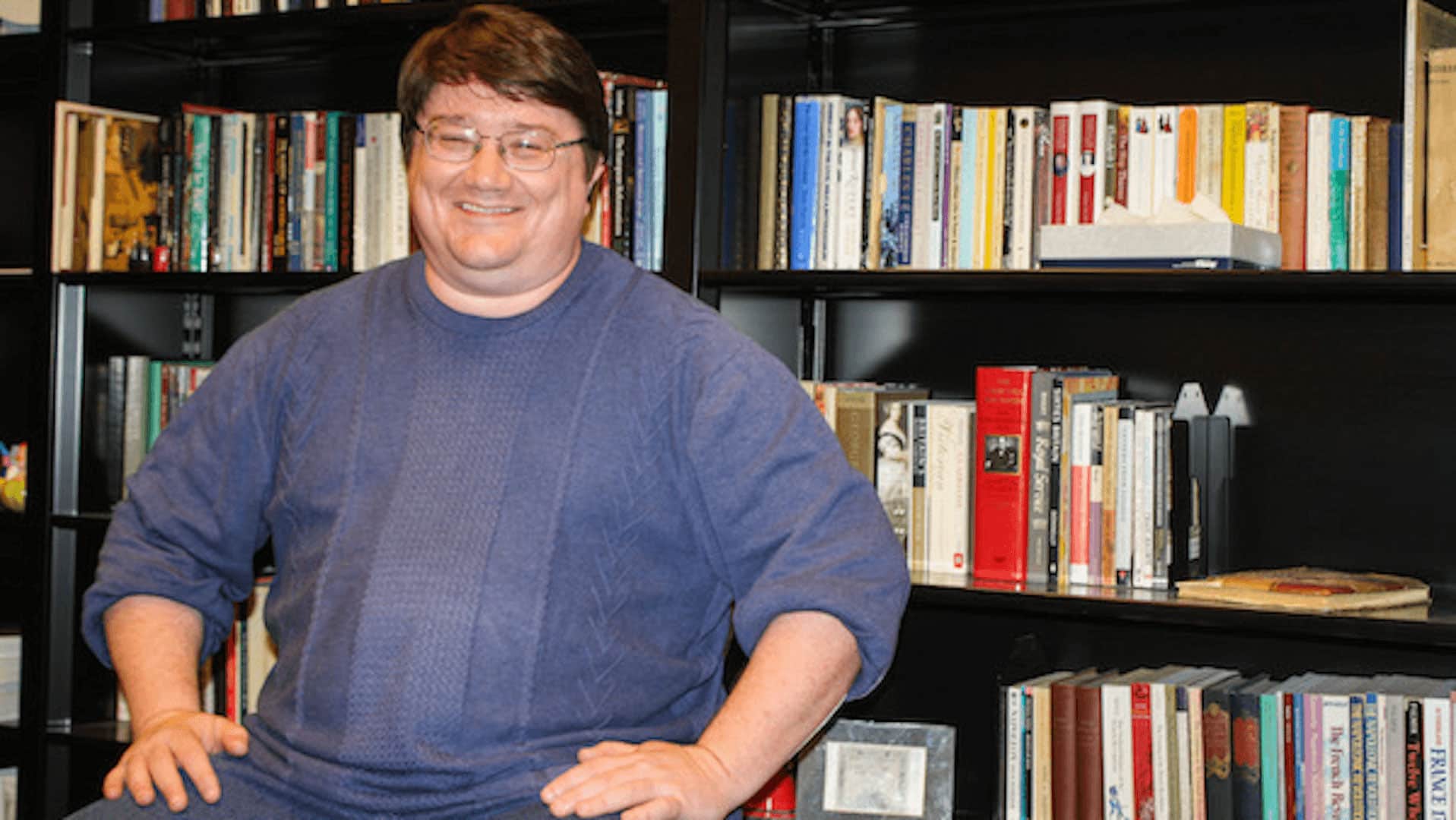 Dr. David Stewart in front of bookshelves.