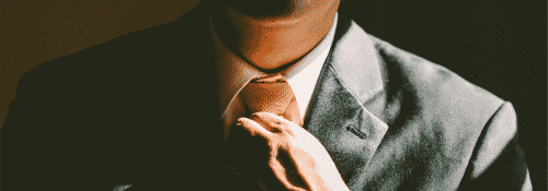 Man adjusting tie