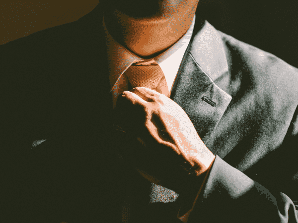 Man adjusting tie