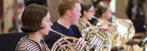 French horn section at orchestra rehearsal.