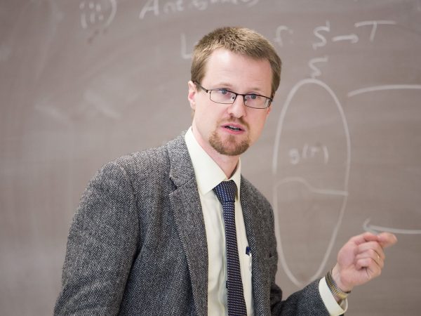 Dr. Gaebler in front of a blackboard, teaching class.