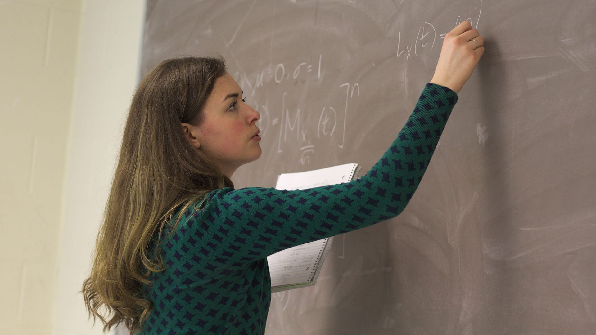 Hannah Andrews writes on a chalkboard