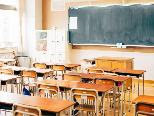 Elementary school classroom with chalkboard and desks.