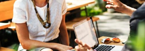 students sitting outside at table stock photo