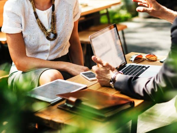 students sitting outside at table stock photo