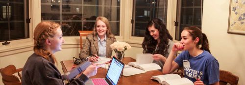 Students studying and conversing around a table.