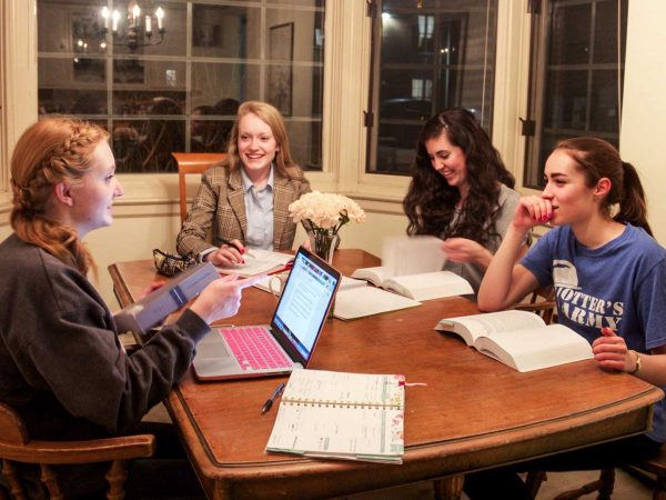 Students studying and conversing around a table.