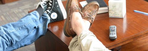 A couple resting their feet on a coffee table, relaxing.