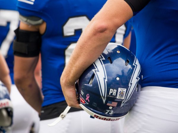 Hillsdale football players holding helmets