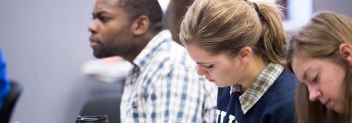 Several students taking notes during class.