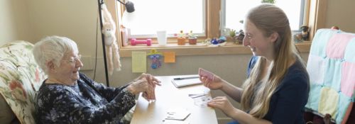 Hillsdale student playing cards with residents of an assisted living facility.
