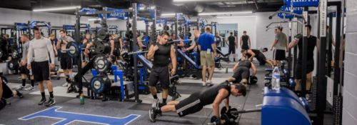 Student athletes exercising in the sports weight room.