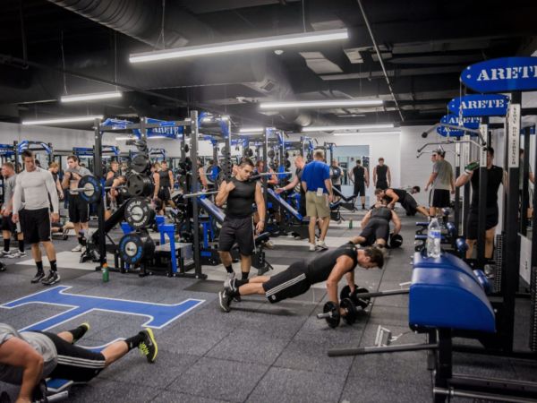 Student athletes exercising in the sports weight room.