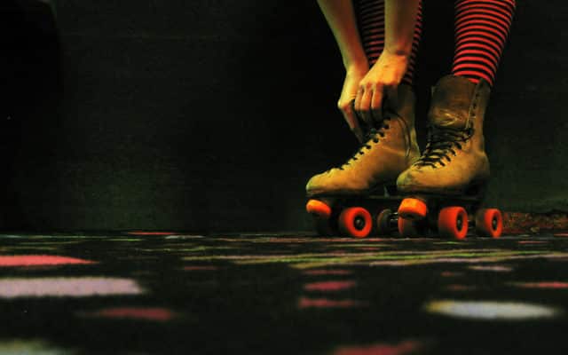 A woman tying her roller skate laces.