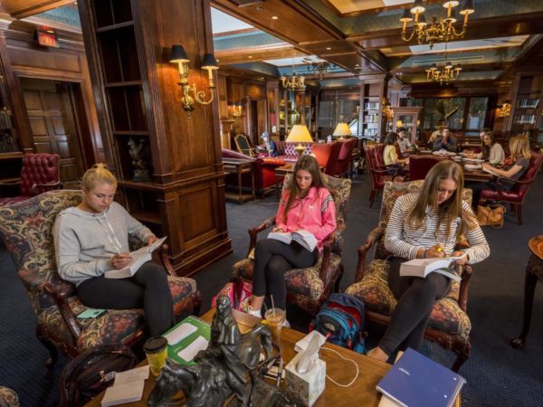 Three students studying in the Heritage room of the Hillsdale College Library..