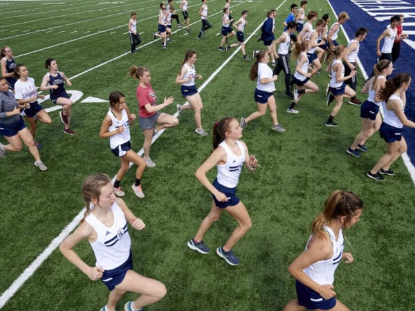 Hillsdale Track team running on the football field during practice.