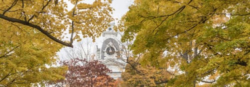 Hillsdale College clock tower through autumn trees