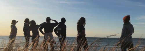 Students on beach at sunset