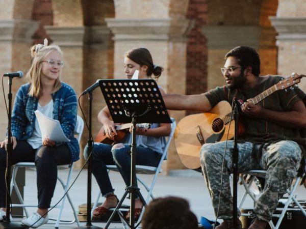 Two male and two female students performing music at an outdoor concert