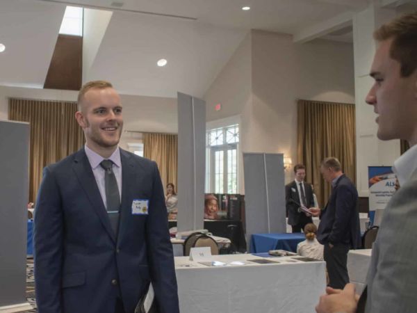 Student speaking with two others at classical school job fair