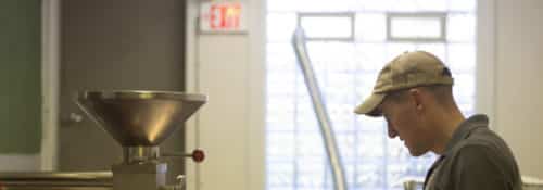 a man stands by a coffee roaster