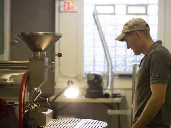 a man stands by a coffee roaster