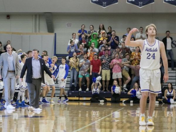 Basketball players, coaches, and student section at a basketball game
