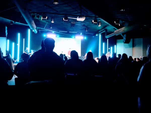 shadows of people at a concert with blue lazers