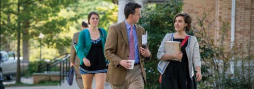 A Hillsdale student speaks with faculty as they walk across campus.