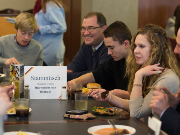 Students with Professor Fred Yaniga at a Stammtisch (German for "regulars' table")—an informal group meeting held on a regular basis, and also the usually large, often round table around which the group meets. A Stammtisch is not a structured meeting, but rather a friendly get-together.