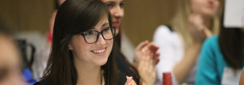 A young alumnus applauds at the Alumni Award Banquet