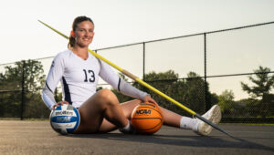 Marilyn Popplewell posed sitting on the ground with sports equipment
